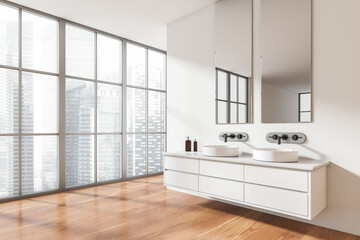 Light bathroom interior with double sink and panoramic window