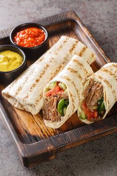 durum doner lavash shaurma meat closeup on the wooden board on the table. Vertical