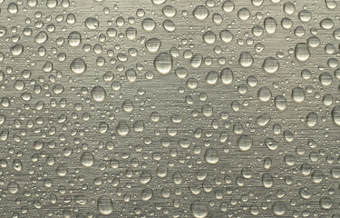 Round water drops on a silver background. Horizontal background in raindrops.
