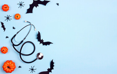 Stethoscope and Halloween decorations on blue background with copy space.