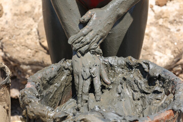 close view of hands dirty of  dead sea mud at the beach