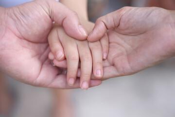 Asian child girl hand with father and mother hand holding daughther for familly bonding love background close up