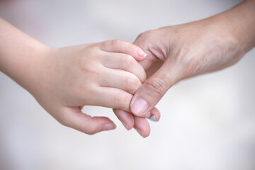 Asian child girl hand with mother hand holding soft focus on background