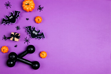 Вumbbells with Halloween decorations on purple.