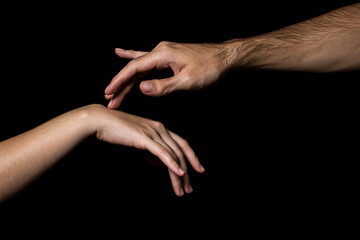 Gentle touch of female and male hands on a black background. Gesture expressing love and tenderness