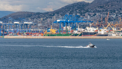 Pilot boat at the port of Piraeus in Greece with shipyards in the background