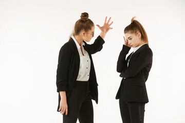 The conflict of two girls in office clothes. Boss and subordinate. Pure white background. The concept of business and corporate relationships in the enterprise.