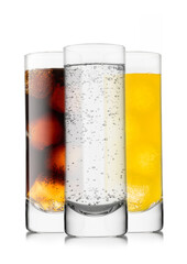 Lemonade soft drink with cola and orange soda with ice cubes in highball glasses on white background.