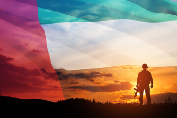 Silhouette of soldier on background of UAE flag and the sunset or the sunrise. Concept of national holidays. Commemoration Day.