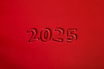 Fototapeta na wymiar Photo of numbers 2025 made of thick clear acrylic glass on a red background. View from above.
