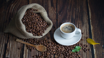 Coffee beans in jute bag-sack and wooden spoon on table