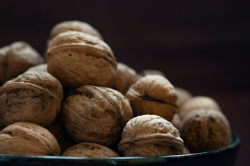 Bowl full of walnuts on black background with copy space