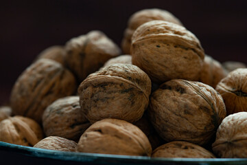 Bowl full of walnuts on black background with copy space