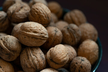 Bowl full of walnuts on black background with copy space