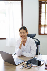 Portrait of an Asian doctor using a computer