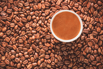 Turkish coffee cup on roasted coffee beans. Top view with close up.