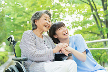車椅子に乗ったシニア女性と女性医療従事者