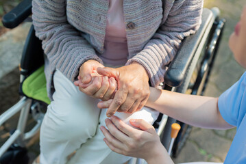 シニア女性の手を握る介護士の手元