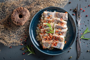 Sour and spicy pickled herring on old fishing net.