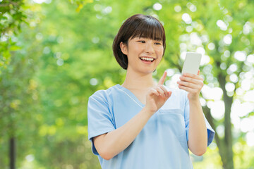 スマートフォンを使う女性医療従事者
