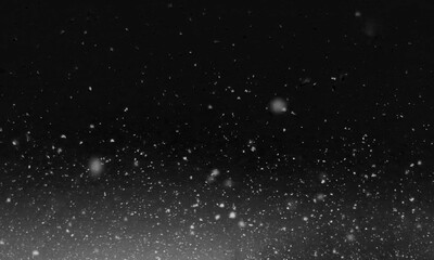 Falling snow at night. Bokeh lights on black background, flying snowflakes in the air. Overlay texture. Snowstorm