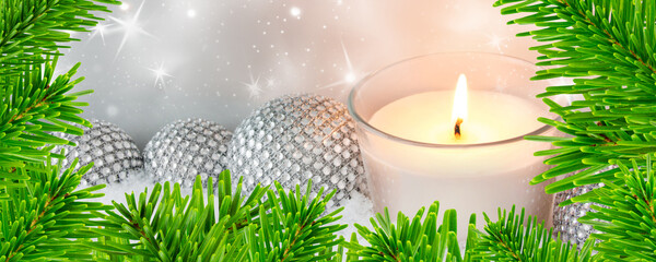 Silver Christmas decoration with candle,  ornaments, fir branches and snow