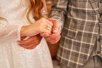 The groom holds the bride's hand in his. Preparation for the wedding. Wedding celebration.