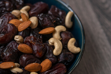 Raw cashew nuts and figs served in black bowl