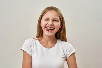 Joking teenage girl wink and stick out tongue - obrazy, fototapety, plakaty