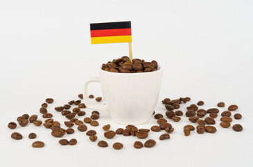 The German flag sticks out of a cup of roasted coffee beans.