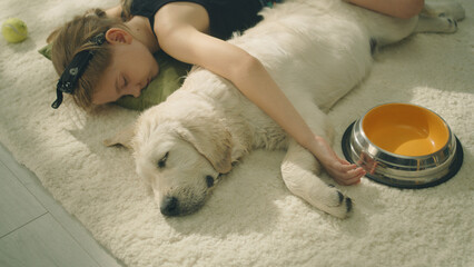 Girl and dog daytime sleeping on mild carpet, on the floor, watching dreams, spending leisure time...