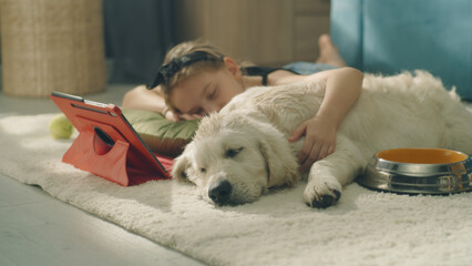 Girl and dog daytime sleeping on mild carpet, on the floor, watching dreams, spending leisure time...