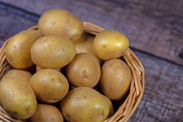 Kartoffeln im Korb auf hölzernen Untergrund