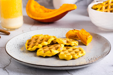 Pumpkin waffles on a plate on the table. Homemade baking.