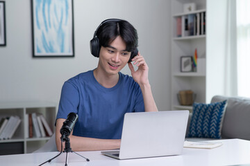 Feeling good happy and positive at work. Young Asian businessman wearing headset on video call with clients on laptop. Young Asian man giving online educational class lecture, consulting customer.