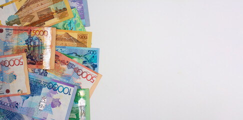 Horizontal banner with banknotes of the Bank of Kazakhstan on a gray background. Kazakhstani cash - tenge. Place for text. Relocation to Kazakhstan. Currency exchange. Copyspace