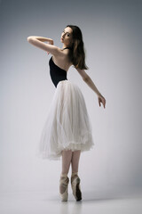 a ballerina in a bodysuit and a white skirt improvises classical and modern choreography in a photo...