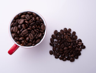 Coffee beans in a red cup on a light background