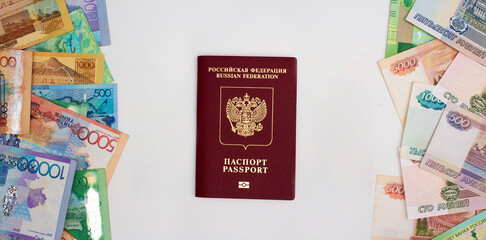 Russian passport on a gray background between cash Russian rubles and Kazakh tenge. Immigration from Russia due to the war in Ukraine and mobilization. Currency exchange for relocation to Kazakhstan