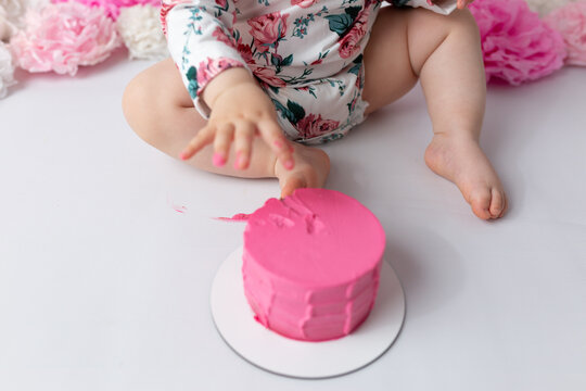 A Small Child By The Hand Takes Out The Number One Of Cake First Cake. The First Day Of Birth. Cake Smash