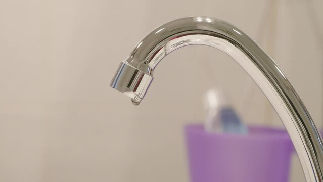 Doigt qui avance pour v&eacute;rifier la fuite d'un robinet de salle de bain avec arr&ecirc;t