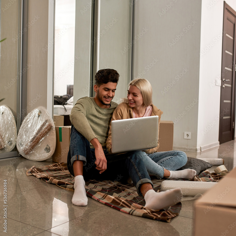 Sticker Couple using laptop on blanket on floor with boxes