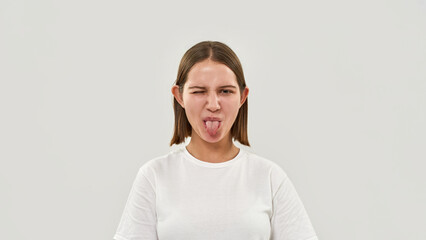 Joking teenage girl wink and stick out tongue