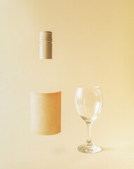 invisible bottle with copy space label and transparent wine glass on pastel sand color background, minimal creative composition.