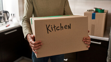 Guy holding box with glass and kitchen things