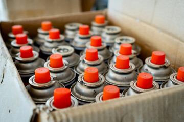 Old and used lubricant spray cans from automotive industry wait for recycling.