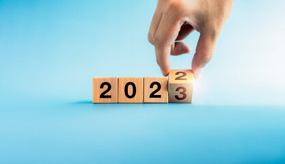 The calendar year 2022 changed to the new year 2022. Close-up hand turning number 2 to 3 on wooden...
