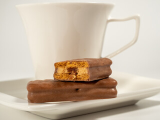 Chocolate bar and a cup of coffee on a white background.