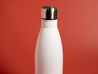 White Thermal bottle on a pink background. Thermos bottle
