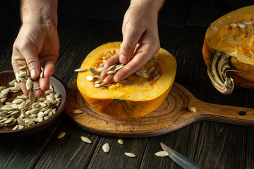 Harvesting pumpkin seeds after harvest for planting next season. Farmer hands during close-up with pumpkin seeds